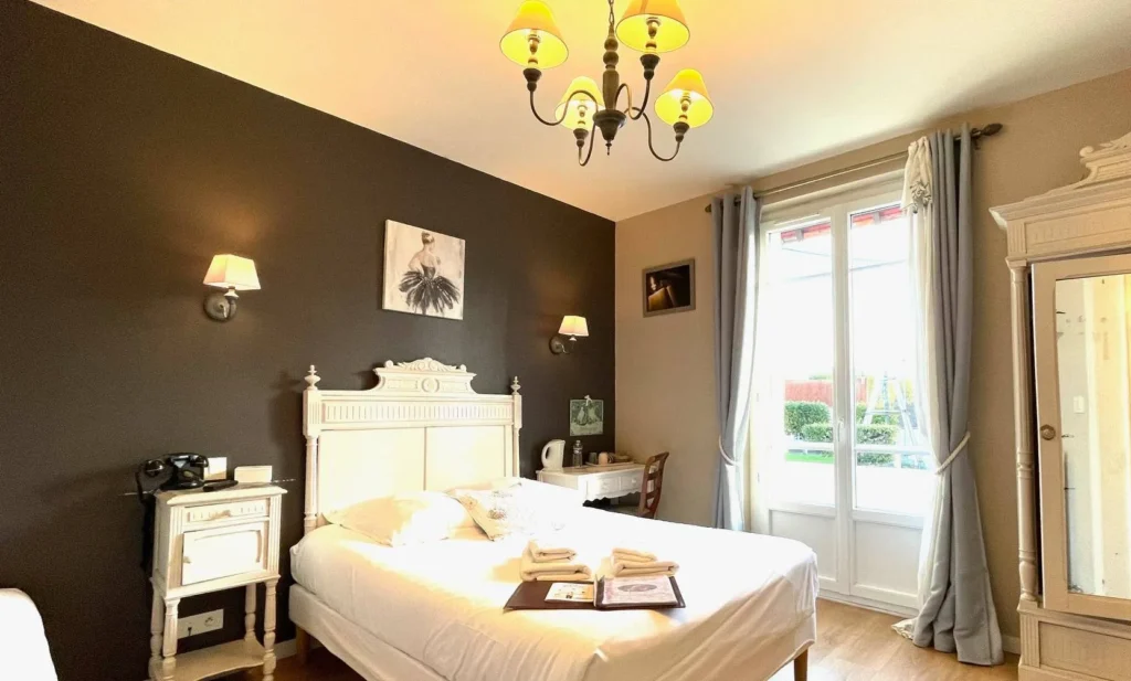 Retro-romantic room at Villa les Mots Passants, with double bed, antique furniture and warm light.